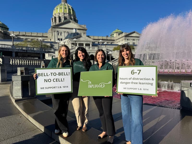 PA Unplugged members with bell-to-bell signs at the Capitol fountain